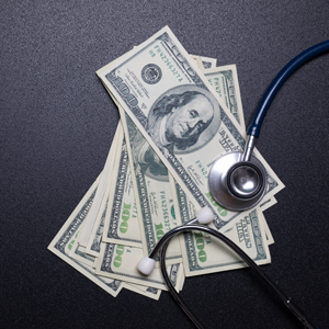 Stethoscope on dollar banknotes, healthcare payment concept
